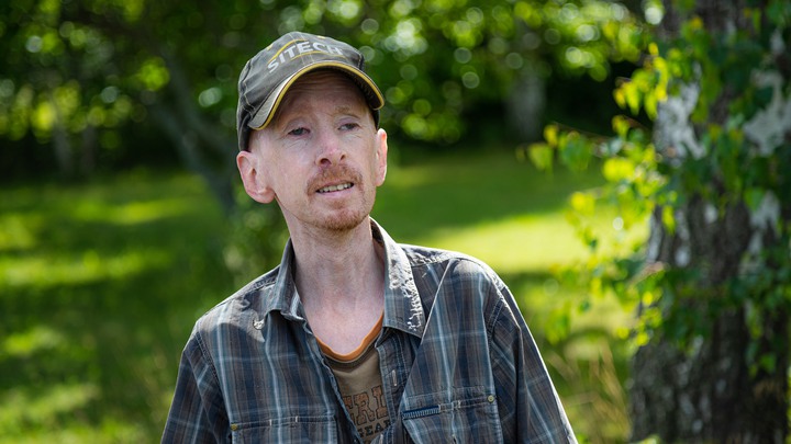 Peter Brolin, 37 år, i keps i sin trädgård.