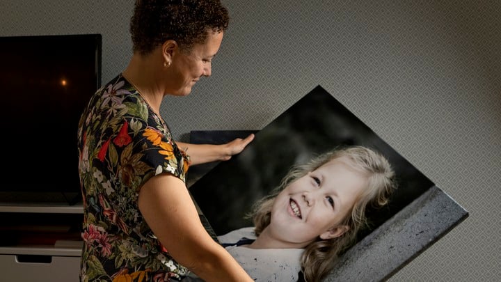 Bilder från Lisannes hem i Floda. Hon tittar på ett stort foto av sin dotter.