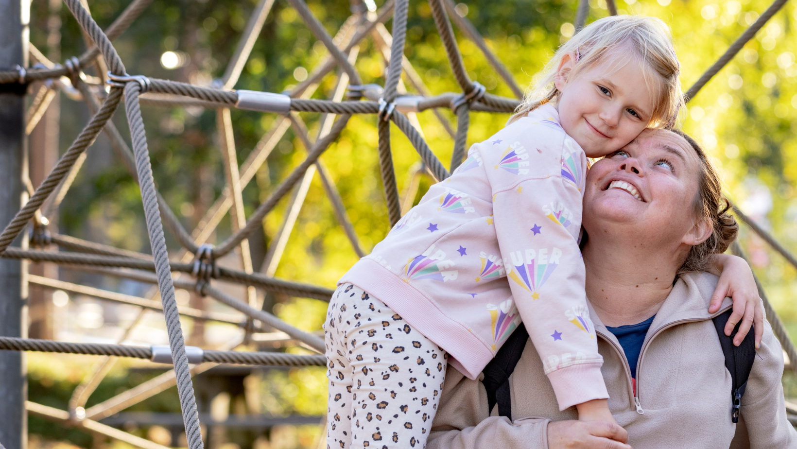 Bilden visar en mamma och dotter som kramar om varandra.