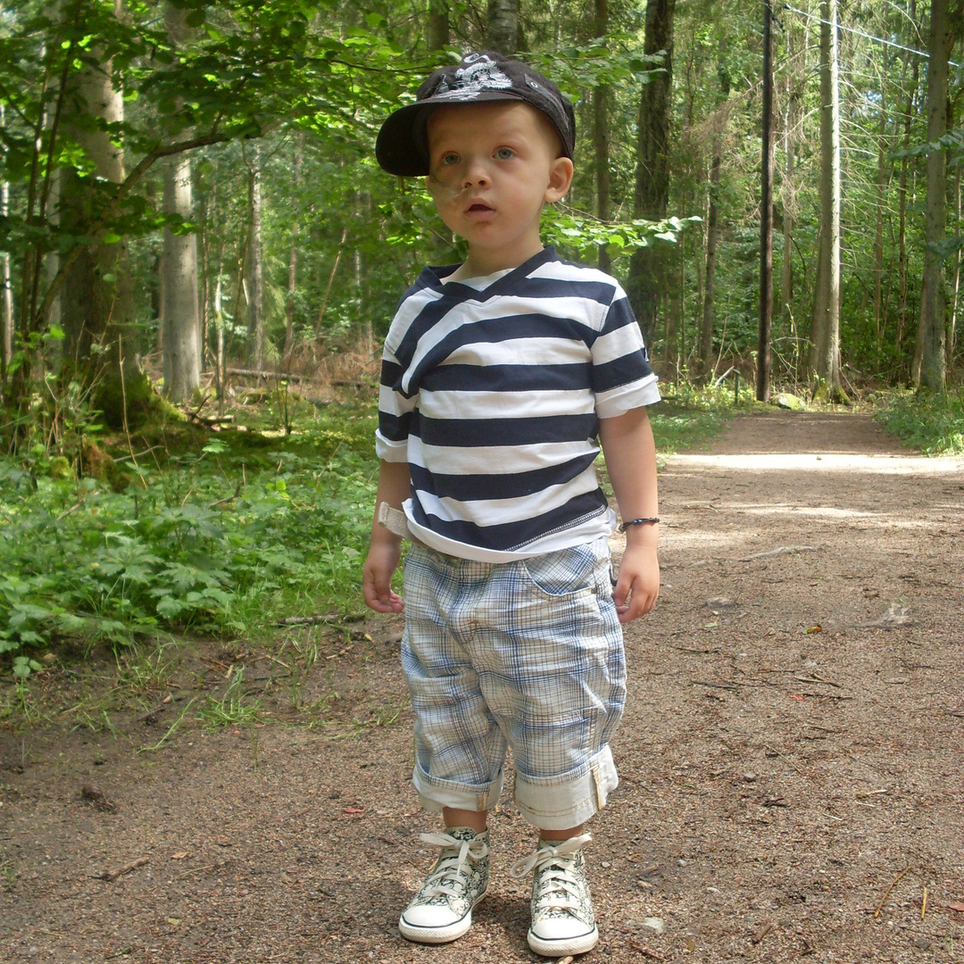 Noel står på en stig i skogen.