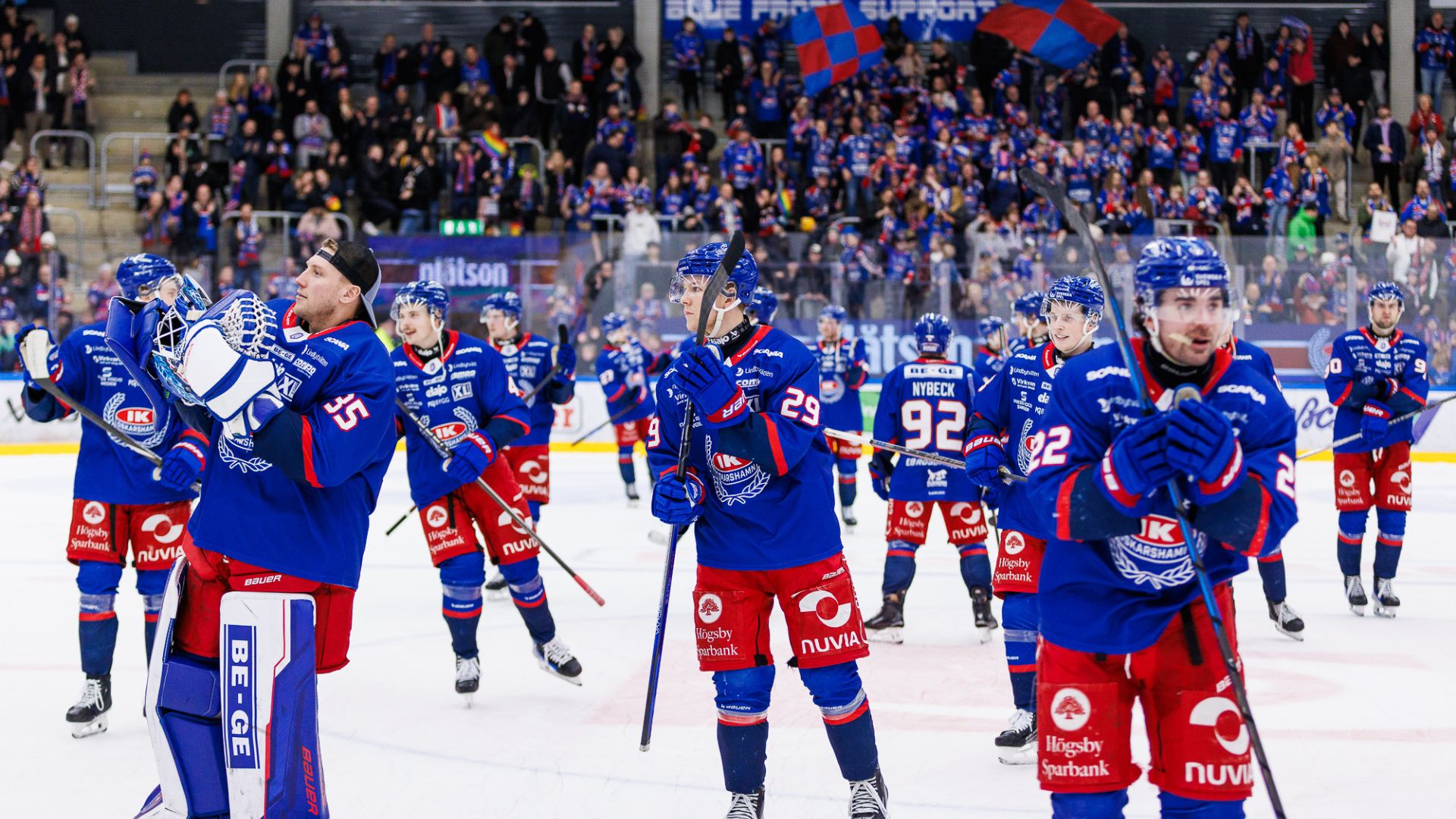 Hockeyspelare klädda i blått och rött ute på isen.