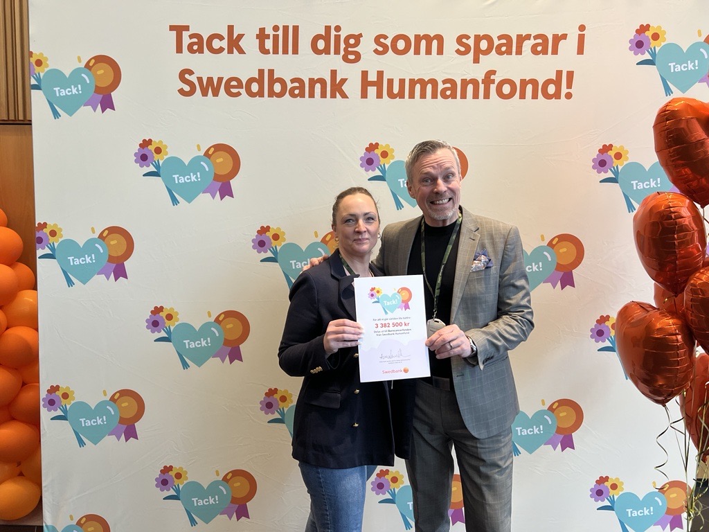 Sara och Magnus håller i en check från Swedbank Humanfond