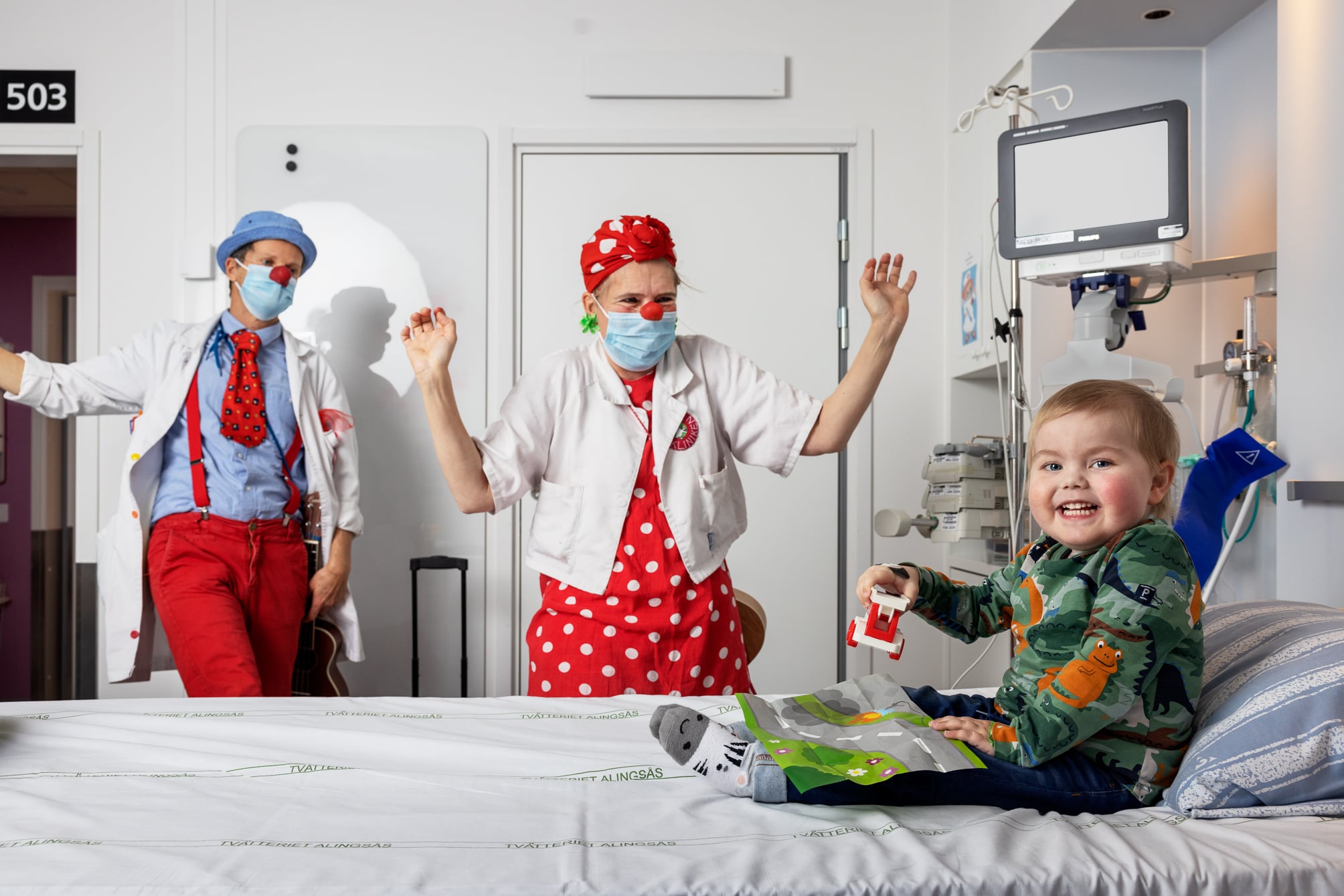 Två clowner som besöker ett sjukt barn på sjukhuset