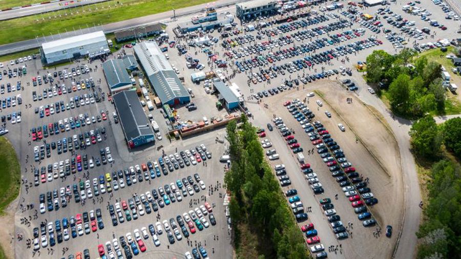 Bild från ovan. Stor parkering med många färglada bilar