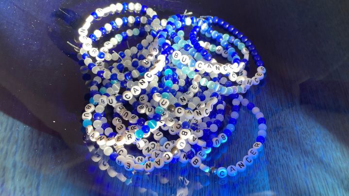 Blåvita armband med text Bu Cancer