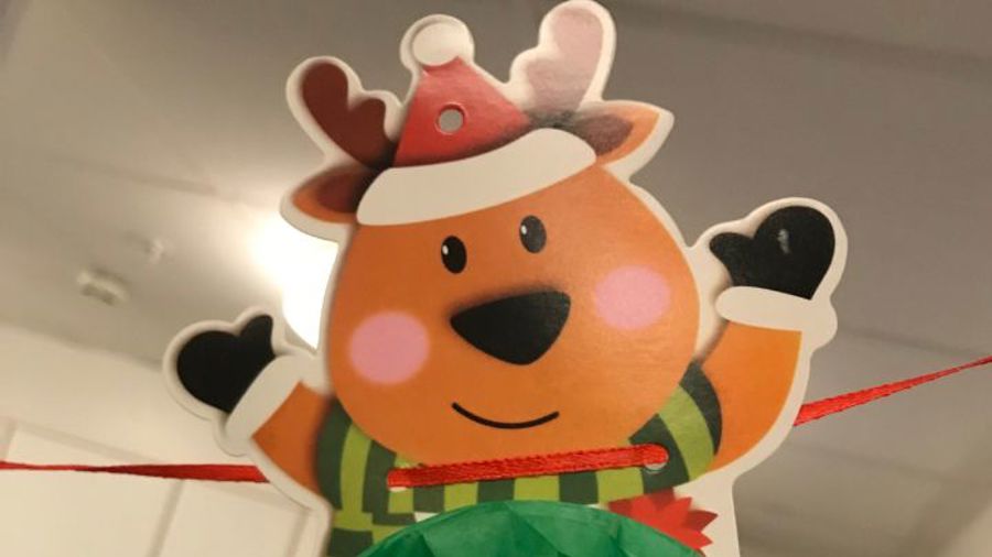 Juldekoration papperfigur ren med tomtemössa och vinkande händer med vantar på